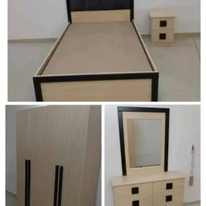 غرفة نوم تشمل سرير وتسريحة صغيرة